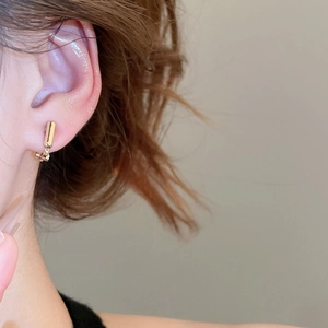 Golden geometric clip-on earring converter shown on female model with minimalist design