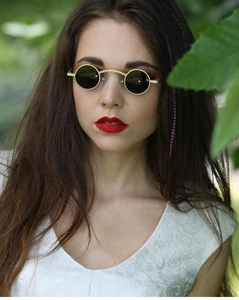 Close-up of steampunk round sunglasses with gold metal frames on a model's face