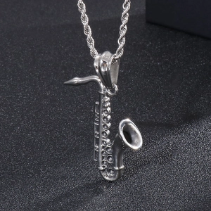 Macro view of vintage silver saxophone pendant with detailed mechanical textures on chain