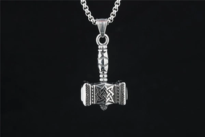 Close-up of vintage stainless steel Viking Mjolnir pendant with Celtic knot engravings