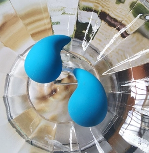 Macro detail of teardrop earrings with matte bright blue finish inside glass decor
