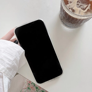 Lifestyle shot of clear cherry phone case on smartphone with coffee cup background