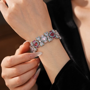 Gros plan sur un bracelet vintage en argent serti de pierres roses, rouges et bleues