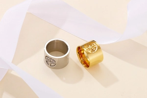 Close-up of gold and silver hollow tree of life rings with polished stainless steel finish