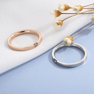 Détail de bagues en acier inoxydable rose doré et argent avec diamant unique minimaliste