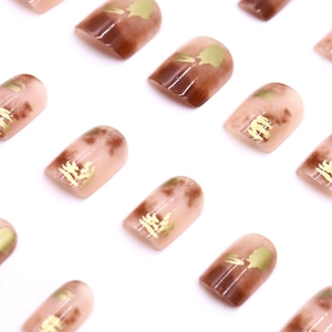 Brown amber gradient press-on nails with gold glitter calligraphy and glossy finish
