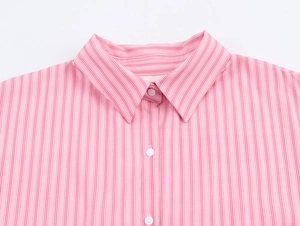 Dettaglio del colletto a rever e abbottonatura di una camicia a righe rosa da donna