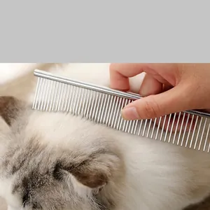 Professional stainless steel pet grooming comb used on long haired cat for styling