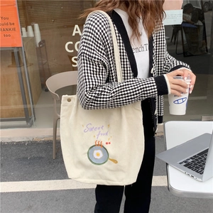 Détail de la broderie d'oeuf au plat et du texte Sweet Food sur le sac en velours côtelé