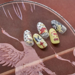 Detail of 3D embossed nail art stickers with traditional Chinese crane and red fan motifs