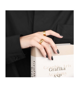 Detail of gold croissant dome ring and double layer band worn on finger for jewelry styling