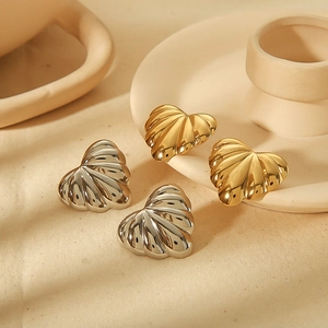 Detailed view of gold and silver heart earrings with textured radiating rib pattern