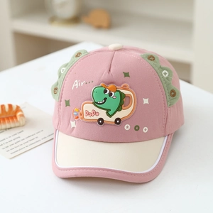 Dettaglio del cappellino bimbo in cotone rosa e beige con ricamo a forma di dinosauro