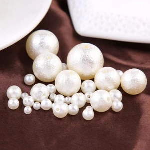 Macro detail of white ABS round wrinkle pearls in various sizes for DIY jewelry crafts