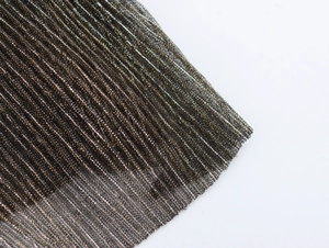 Macro shot showing detailed texture of sparkling gold and silver mesh fabric for party dress