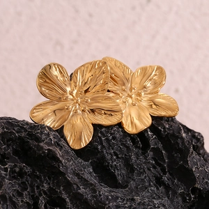 Detail of 18K gold-plated stainless steel flower earrings with brushed metal texture