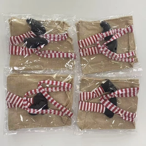 Dettaglio di quattro coprigambe per sedie elfo di Natale in lino con calze a righe rosse