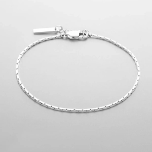 Détail d'un bracelet gourmette en acier titane argenté avec un fermoir mousqueton robuste