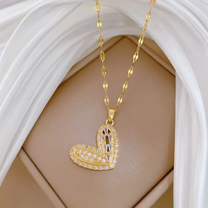 Macro shot of gold-plated heart pendant with brilliant cubic zirconia stones on silk