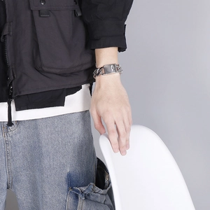 Close-up of a chunky silver stainless steel chain bracelet worn on a man's wrist