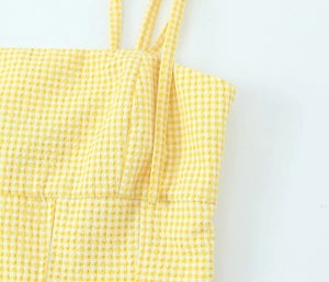 Details des gelben Gingham-Seersucker-Stoffs und schmaler Träger des figurbetonten Tops