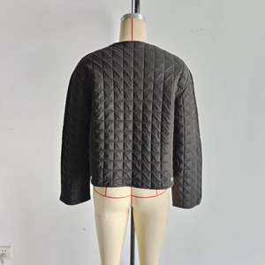 Detail of black quilted puffer jacket featuring square pattern stitching and satin finish