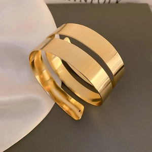 Dettaglio ravvicinato di un bracciale a spirale dorato a doppio strato lucido a specchio