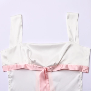 Nahaufnahme des weißen Satin-Oberteils mit quadratischem Ausschnitt und rosa Schleife
