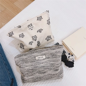 Detail of minimalist floral embroidered canvas and tweed pouch with simple wish label