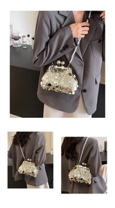 Detail of luxury evening clutch with gold sequins, pearls, and a vintage metal clasp