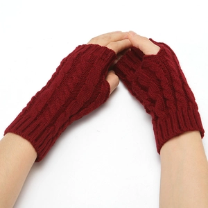 Close-up of wine red cable knit fingerless gloves showing thick woolen texture on model