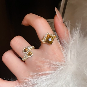 Detailed macro view of two vintage tiger eye rings with zircon and pearl embellishments
