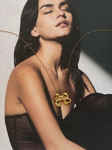 Detailansicht einer polierten goldenen Schleifenkette, elegant auf einem Modemagazin