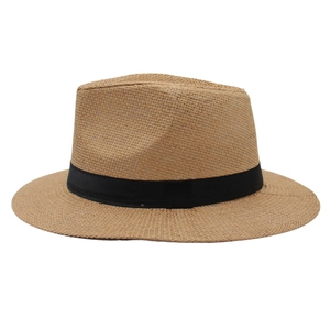 Détail d'un chapeau Panama en paille marron clair avec ruban noir et texture tissée