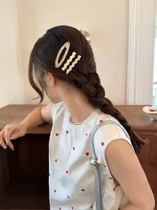 Detail view of acetate marble oval hair clip and white wave barrettes on model