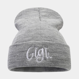 Detailed view of the Gigi embroidery on a soft light grey knitted beanie cap
