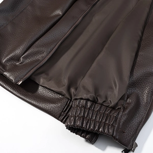 Détails des poignets côtelés et de l'ourlet d'une veste en cuir marron avec fermeture éclair