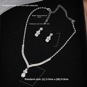 Macro detail of bridal jewelry set with sparkling zircon tassels and silver V-shaped design