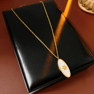 Detail of vintage sun oval pendant necklace resting on a premium black leather jewelry box
