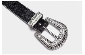 Close-up of black textured belt with shiny silver horseshoe buckle and rhinestones