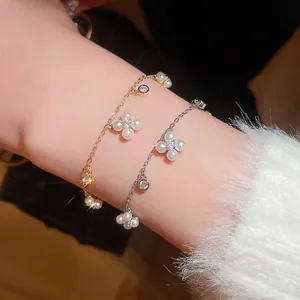 Elegant gold and silver charm bracelets with pearl clover and zircon accents on wrist