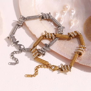 Detail of silver and gold barbed wire bracelets with micro-pave crystals and 18K hallmarks