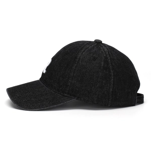 Detail view of washed black denim baseball cap with white embroidered R letter