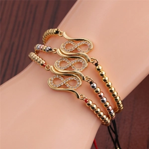 Detail showing infinity symbol bracelets in gold, rose gold and silver with zircon