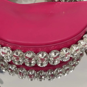 Macro detail of sparkling round rhinestones on premium hot pink leather shoulder bag