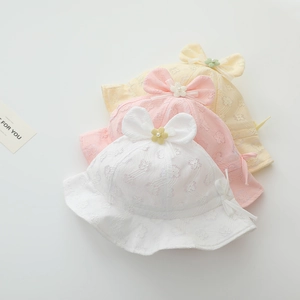 Detailed close-up of baby lace sun hats in soft white pink and yellow with bow accents