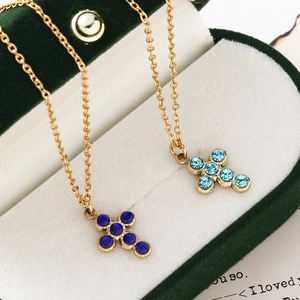 Golden stainless steel cross pendant necklaces with blue crystal stones in a velvet box