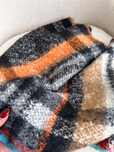 Macro shot of plaid wool blend fabric texture with gray and orange checked pattern