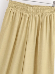 Détail du pantalon à taille haute et jambe large montrant la taille élastique et le tissu