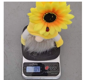 Dettaglio dello gnomo di peluche girasole pesato su una bilancia digitale